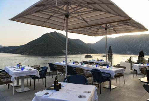 a restaurant with tables and chairs and an umbrella at Santa Boka in Perast