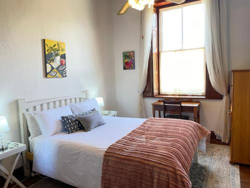 a bedroom with a bed and a window at Albert Manor guest house in Ladismith