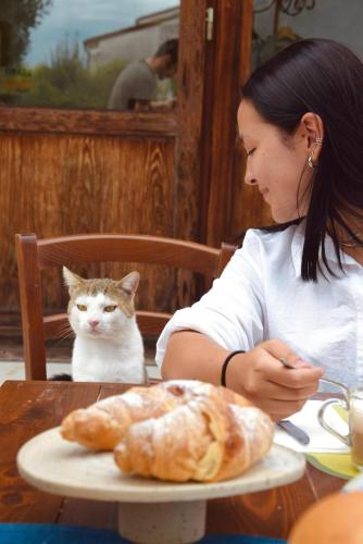 a woman sitting at a table with a plate of bread at Colombara Farmhouse in Mestrino