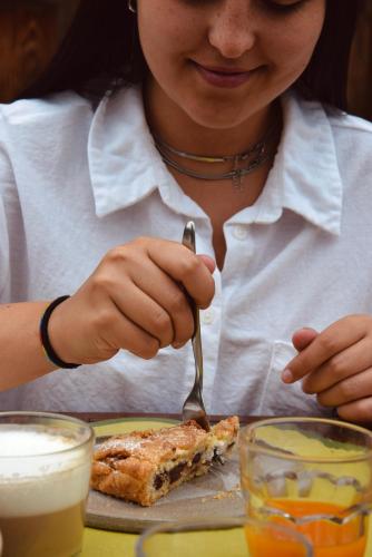 a woman eating a piece of food with a fork at Colombara Farmhouse in Mestrino
