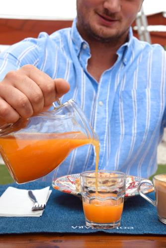 a man is pouring orange juice into a glass at Colombara Farmhouse in Mestrino