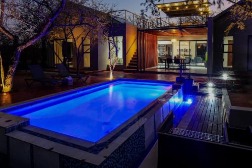 a swimming pool in a backyard at night at Amani Luxury Villa Marloth Park in Marloth Park