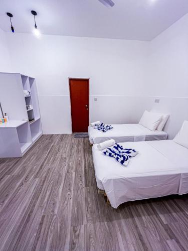 a room with two beds and a red door at Shadow Isles Himandhoo in Himandhoo 