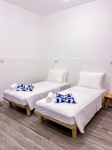 three beds in a room with blue and white towels on them at Shadow Isles Himandhoo in Himandhoo 