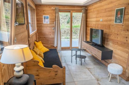 a living room with a couch and a television at Résidence Pramouton - Charmant logement au cœur d’un chalet de montagne MAE-3601 in Le Mélézet