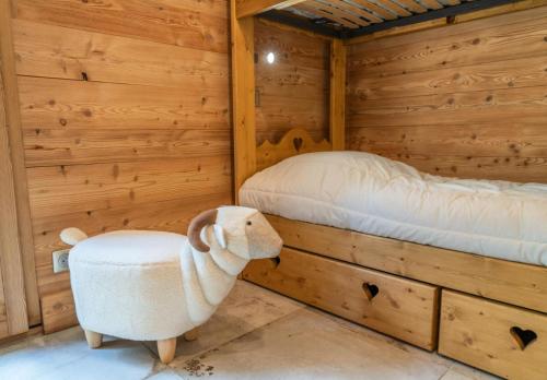 a log cabin with a bed and a stuffed animal at Résidence Pramouton - Charmant logement au cœur d’un chalet de montagne MAE-3601 in Le Mélézet