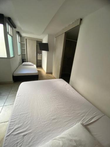 a bedroom with two white beds in a room at Tauro Black Suites Cerca al estadio Atanasio Girardot in Medellín