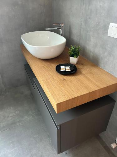 a bathroom with a white sink on a wooden counter at La Casetta di Tommi in Sandra