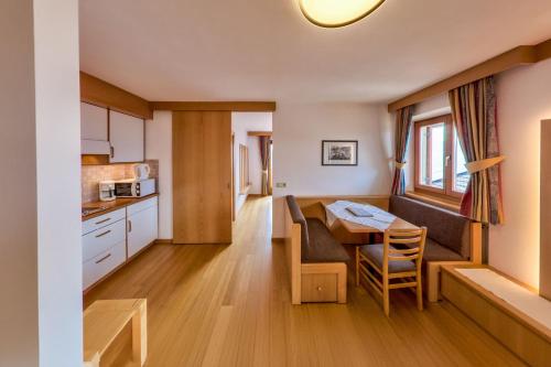 a kitchen and dining room with a table and a dining room at Wohnung Mölten in Meltina