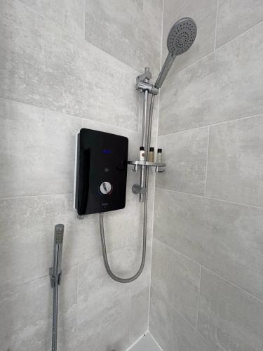 a shower with a shower head in a bathroom at Spacious John York House & Parking in Doncaster