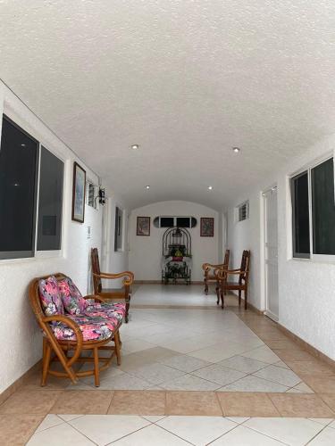 a living room with chairs and a couch at La Orquidea Bonfil in Acapulco