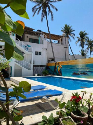 a swimming pool with two lounge chairs next to a building at La Orquidea Bonfil in Acapulco