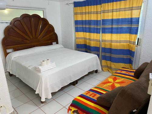 a bedroom with a bed with two towels on it at La Orquidea Bonfil in Acapulco
