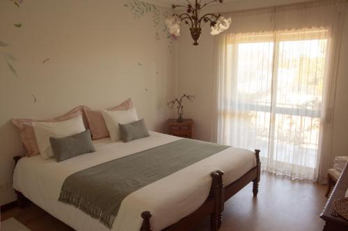 a bedroom with a large bed and a window at Swara Slow Living Home in Aveiro