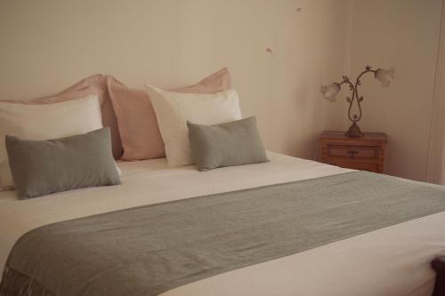 a bedroom with a large bed with pillows at Swara Slow Living Home in Aveiro