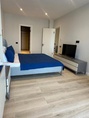 a bedroom with a blue bed and a television at Sea breeze Park Residens 2 in Nardaran