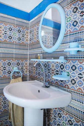 a bathroom with a sink and a mirror at Loft Deluxe avec accès Piscine in Tozeur