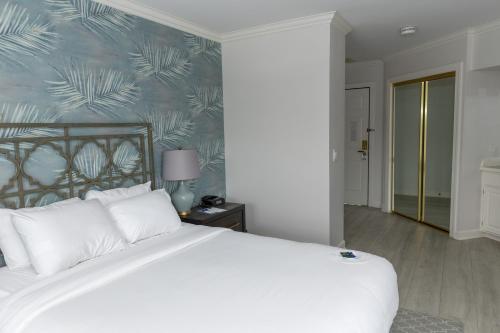 a bedroom with a white bed and a blue wall at The Geneva Inn in Lake Geneva