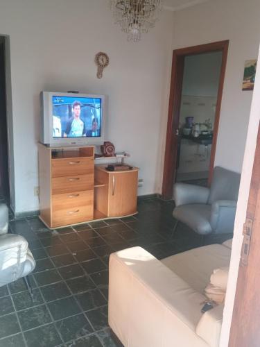 a living room with a tv and a couch at Casa de temporada 2 in Serra Negra