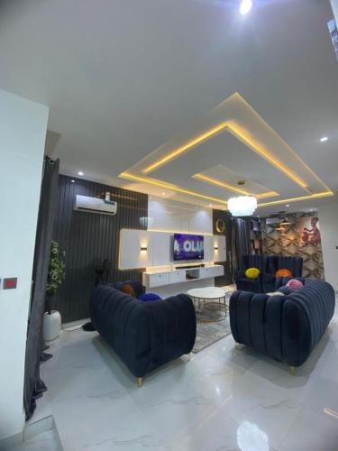a living room with two blue couches and a tv at BoladHomes in Mama