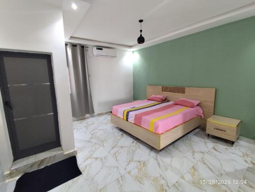 a bedroom with a bed and green walls at Appartement meublé Thiès in Thiès