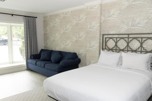 a bedroom with a bed and a blue couch at The Geneva Inn in Lake Geneva