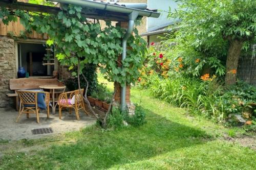 a garden with a table and chairs under a pergola at Enjoy forest tranquility & panoramic views 