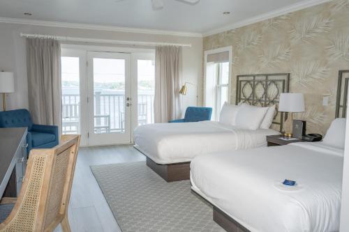 a hotel room with two beds and a balcony at The Geneva Inn in Lake Geneva