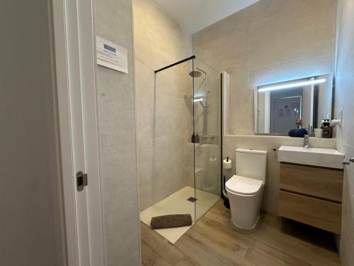 a bathroom with a shower and a toilet and a sink at Apartamentos Matilda Conil - Playa in Conil de la Frontera