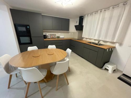 una cucina con tavolo di legno e sedie bianche di Large 85 m2 duplex apartment a Fleurieux-sur-lʼArbresle