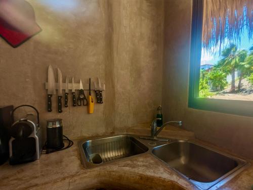 トドス・サントスにあるAlegria Suites at La Poza Beachのシンクと窓のあるキッチンカウンター