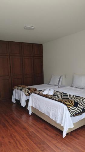 two beds sitting next to each other in a bedroom at Hospedagem Jardim Social,Quartos Econômicos e Suítes, Estacionamento Grátis in Curitiba