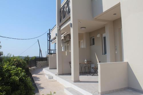 a balcony of a building with a table and chairs at Anemomilos View in Koskinou