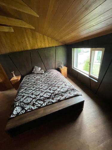 Una cama grande en una habitación con techo de madera. en Chalet in Liptovský Ján, en Liptovský Ján