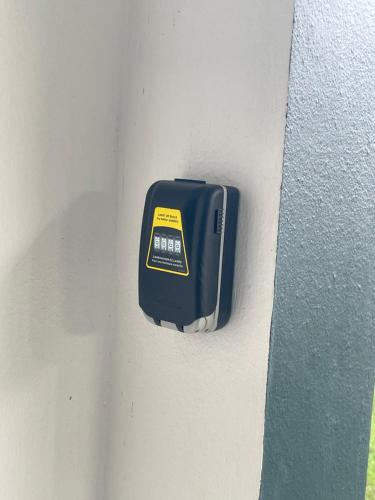 a black electrical box on the side of a wall at Tycoon in Matoury