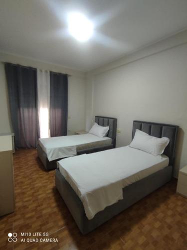 a bedroom with two beds and a light on the ceiling at Relax Apartament in Vlorë