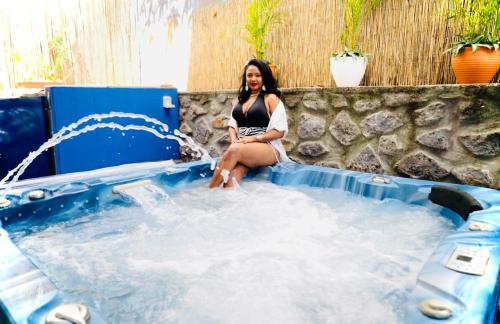 a woman sitting in a hot tub in a pool at Maison Neuve - Spa Confort-6 personnes max-Le Havre in Saint-Pierre