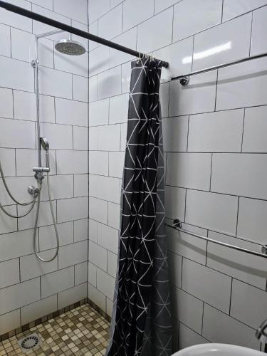 a shower with a black shower curtain in a bathroom at Nice Life appartments in Willemstad
