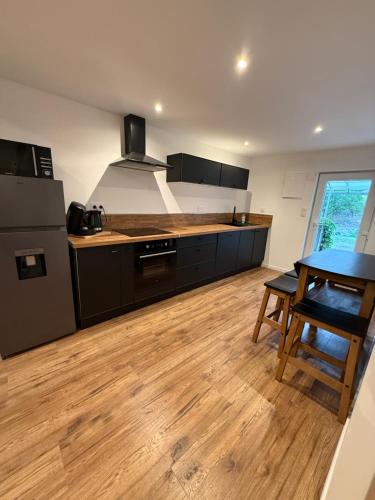 a kitchen with black cabinets and a wooden floor at Domaine St georges in Lazer