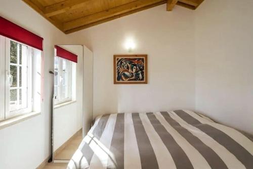 a bedroom with a bed with a painting on the wall at One Bedroom Chalet with private bathroom and kitchen in Alcobaça
