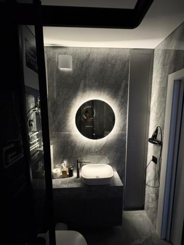 ein Badezimmer mit Waschbecken und Spiegel in der Unterkunft ЖК Панорама Парк Костанай in Qostanai