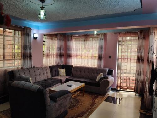 a living room with a couch and a table at Balozi Homes Nyeri in Nyeri
