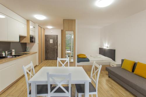 a kitchen and a living room with a table and a couch at K2 Apartamenty in Karpacz