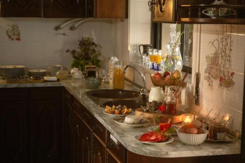 a kitchen counter with a sink and some food on it at Swara Slow Living Home in Aveiro