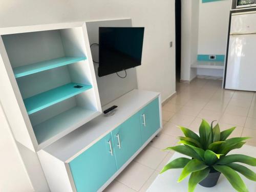 un soggiorno con una TV in un mobile bianco e blu di SOL VELEROS Puerto Rico Apartement a Puerto Rico de Gran Canaria