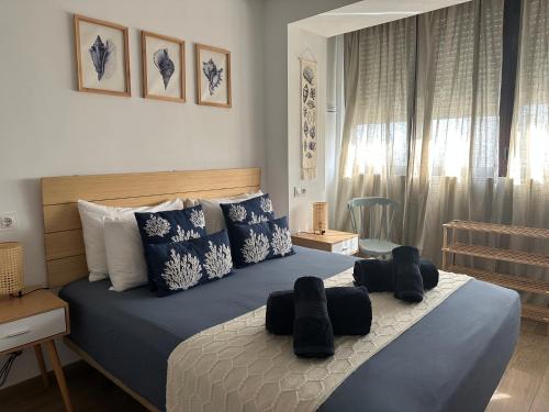 a bedroom with a bed with blue and white pillows at Apartamentos Matilda Conil - Playa in Conil de la Frontera