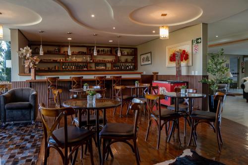 a restaurant with tables and chairs and a bar at Lagoa Parque Hotel in Lagoa Vermelha