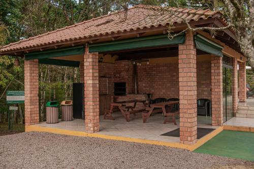 a brick pavilion with a picnic table and a grill at Lagoa Parque Hotel in Lagoa Vermelha