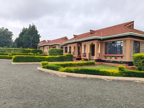 a house with a lot of bushes in front of it at Balozi Homes Nyeri in Nyeri