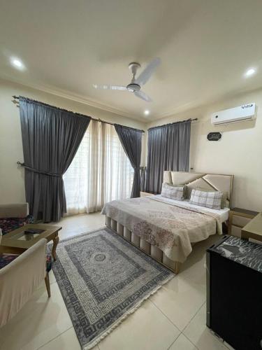 a bedroom with a large bed and a large window at Alpine lodges in Islamabad